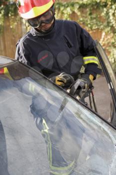Royalty Free Photo of a Firefighter Cutting a Windshield