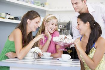 Royalty Free Photo of a Three Women in a Coffee Shop Looking at Desserts