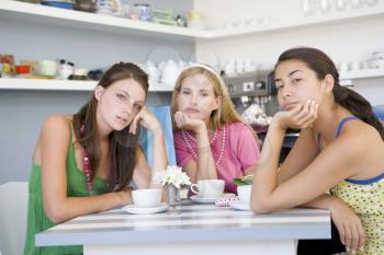 Royalty Free Photo of Three Bored Women at a Table