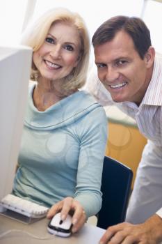 Royalty Free Photo of a Man and Woman Smiling Beside a Computer