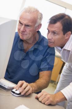Royalty Free Photo of Two Men Looking at a Computer