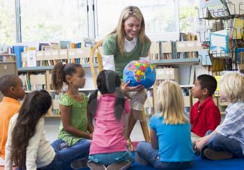 Royalty Free Photo of a Teacher Showing Her Students a Globe