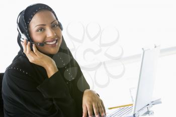 Royalty Free Photo of a Woman Wearing a Headset at a Laptop