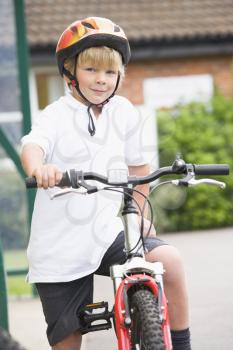 Royalty Free Photo of a Young Boy Getting on a Bike