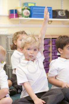 Royalty Free Photo of a Student in Class With His Hand Raised