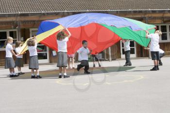 Royalty Free Photo of Students Playing Outside With a Parachute