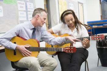Royalty Free Photo of a Student Taking Guitar Lessons