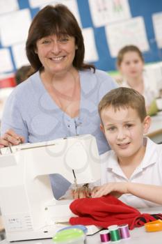 Royalty Free Photo of a Boy Sewing and a Teacher