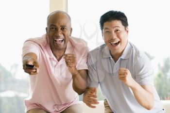 Royalty Free Photo of Two Men With a Remote Control Cheering