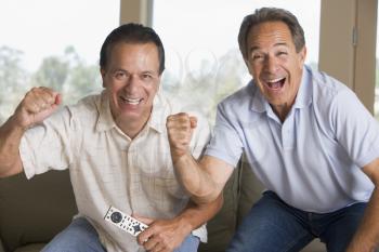 Royalty Free Photo of Two Cheering Men With a Remote