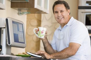 Royalty Free Photo of a Man With Coffee at a Computer