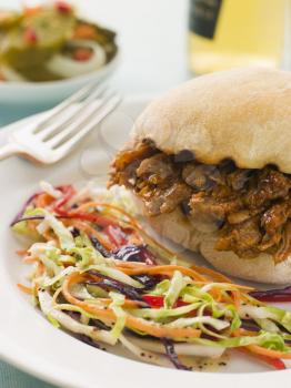 Royalty Free Photo of Pulled Pork and Barbeque Sauce Roll with Seeded Slaw and Gherkins