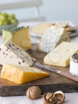 Royalty Free Photo of a Selection of British Cheeses with Walnuts Biscuits and Grapes