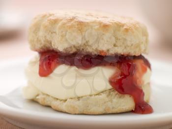 Royalty Free Photo of Scone Filled with Strawberry Jam and Clotted Cream on a plate