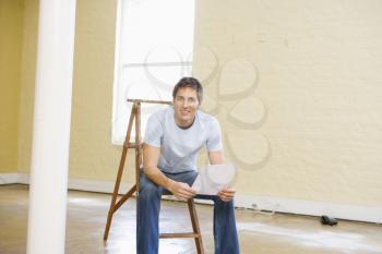 Royalty Free Photo of a Man on a Ladder in an Empty Room