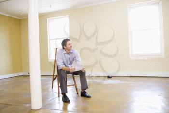 Royalty Free Photo of a Man on a Ladder in an Empty Room