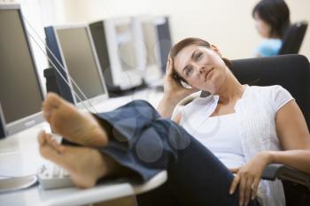 Royalty Free Photo of a Woman Relaxing at a Computer With Her Feet Up