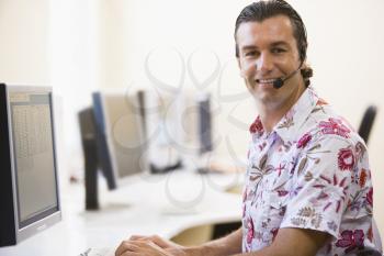 Royalty Free Photo of a Man Wearing a Headset at a Computer