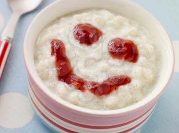 Royalty Free Photo of a Bowl of Creamed Rice Pudding With a Strawberry Jam Face