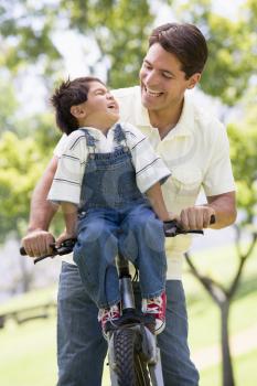 Royalty Free Photo of a Man and Boy on a Bike