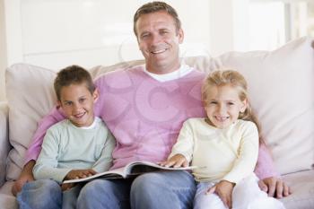 Royalty Free Photo of a Man Reading a Book to Two Children