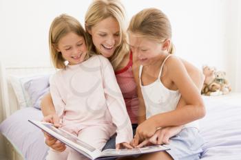 Royalty Free Photo of a Woman Reading to Two Girls