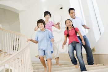 Royalty Free Photo of a Family Running Down a Staircase