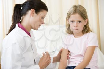 Royalty Free Photo of a Doctor Giving a Girl a Needle