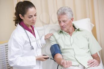 Royalty Free Photo of a Doctor Checking a Man's Blood Pressure
