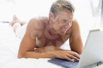 Royalty Free Photo of a Man in Bed With a Laptop