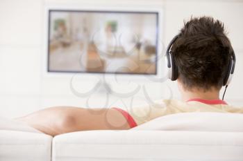 Royalty Free Photo of a Man Watching Television and Wearing Headphones
