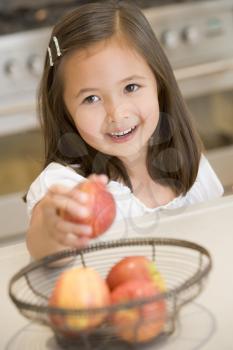 Royalty Free Photo of a Girl Getting an Apple