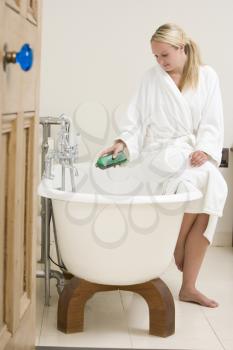 Royalty Free Photo of a Woman Beside a Bathtub