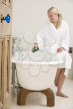 Royalty Free Photo of a Woman Putting Bubble Bath in a Tub