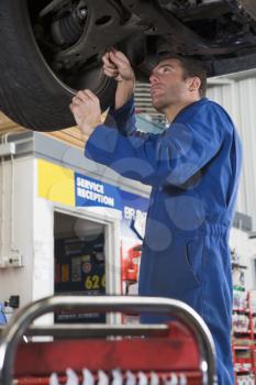 Royalty Free Photo of a Mechanic Under a Car