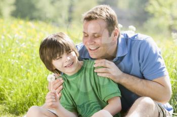 Royalty Free Photo of a Father and Son With a Dandelion