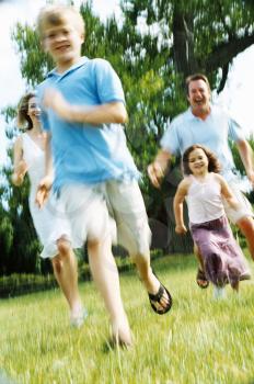 Royalty Free Photo of a Family Running Outside