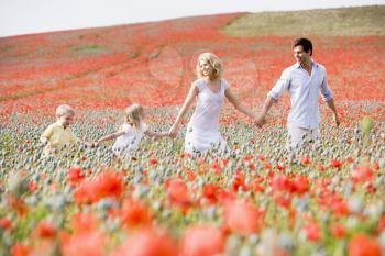 Royalty Free Photo of a Family Walking in a Poppy Field