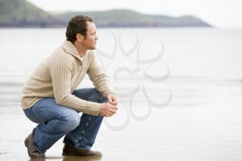 Royalty Free Photo of a Man Crouching on the Beach