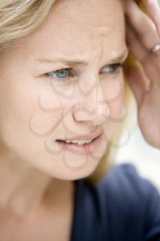 Royalty Free Photo of a Woman Frowning and Holding Her Head