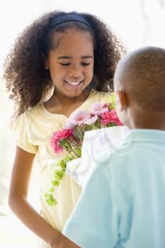 Royalty Free Photo of a Little Boy Giving a Little Girl Flowers