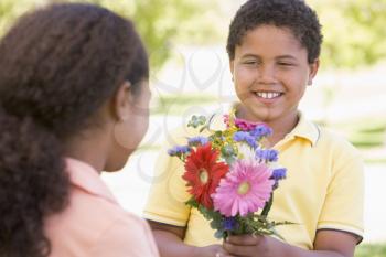 Royalty Free Photo of a Boy Giving a Girl Flowers