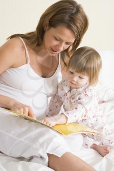 Royalty Free Photo of a Pregnant Woman Reading to Her Daughter