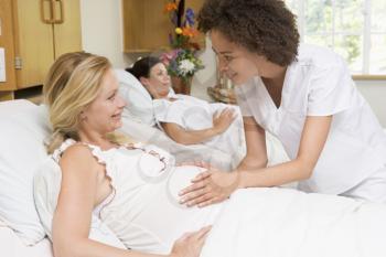 Royalty Free Photo of a Nurse Checking a Pregnant Woman's Belly
