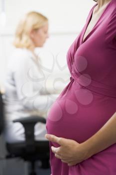 Royalty Free Photo of a Pregnant Worker in an Office