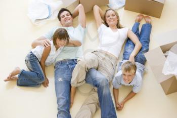 Royalty Free Photo of a Family Lying on the Floor Amid Unpacked Boxes