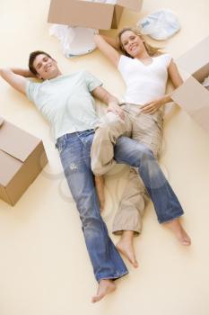 Royalty Free Photo of a Couple Lying on the Floor Amid Boxes