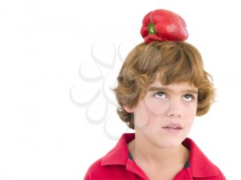 Royalty Free Photo of a Boy With a Red Pepper on His Head