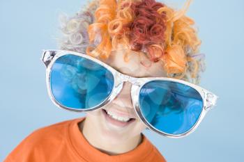 Royalty Free Photo of a Boy Wearing a Clown Wig and Big Sunglasses