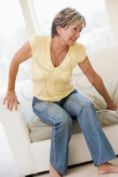 Royalty Free Photo of a Woman Sitting on a Couch in Pain